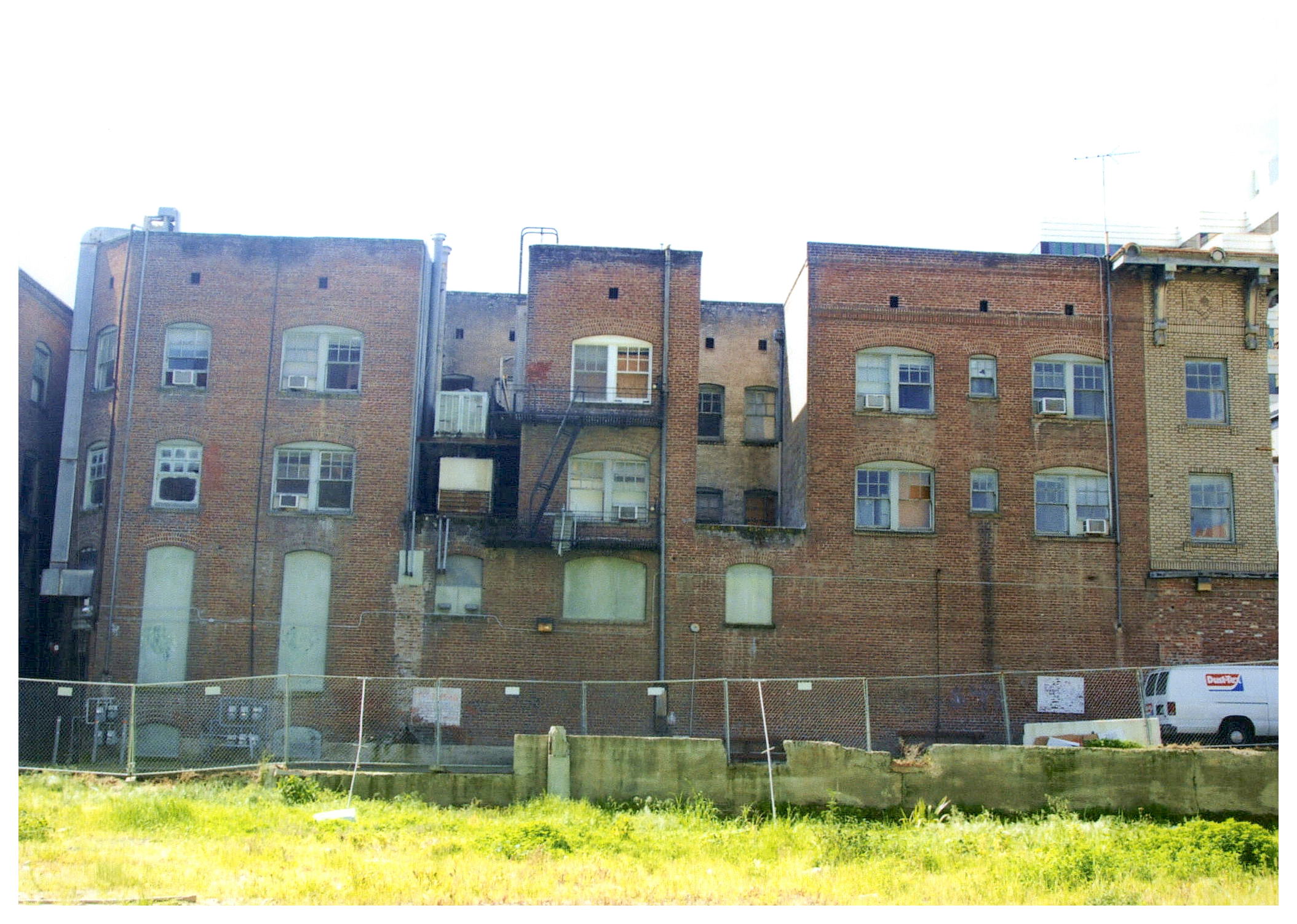 Before: side view of north facade showing missing and damaged windows.